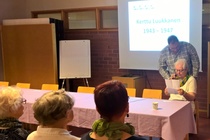 Kuvassa seuran puheenjohtaja Harri O. Halko sovittelee langatonta mikrofonia Kerttu Luukkasen pään ympärille. 

Halko oli työllistetty koko tilaisuuden ajan. Alussa hän loi katsauksen Savonlinnan kansakouluopetuksen sekä Puistokadun koulurakennusten vaiheisiin a esitteli arkkitehti Wivi Lönnin. Tilaisuuden jatkuessa Halko huolehti, että mikrofoni siirtyi esiintyjältä toiselle. Kun yksittäiset esitykset oli pidetty ja muistelijat järjestetty paneeliksi yleisön eteen, Halko juoksutti mikrofonia yleisön joukossa kyselijöille ja kertojille.

Kerttu Luukkasen (koulussa 1943 – 1947) muistoissa oli tragikoomisia aineksia. Koulun ikkunasta haikeana toisten piirileikkiä seurannut järjestäjä olikin lopulta ainoa, joka välttyi jälki-istunnolta, kun villiintynyt tyttöjoukko sieppasi piirin keskelle pojan ja heittäytynyt tämän päälle tukehduttavaksi kasaksi. Toinen palkinto raittiuskilpakirjoituksissa aiheutti taas ongelmia kotona. Sotaleskeksi jäänyt yhden lapsen äiti ei yhtään tykännyt, että tytär kirjoitti juopon isän kuusilapsisesta perheestä.

Kuva: TA
