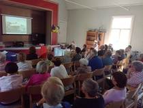 Yleisöä saapui paikalle salin täydeltä. Seurakuntakeskuksesta tien toiselta puolelta lainatuista tuoleista ei monikaan  jäänyt tyhjäksi. Yleisön joukossa oli Ilolan entisiä lastentarhalapsia ja opettajia, rukoushuoneessa pyhäkoulua käyneitä, sekä mm. tiloissa asunut vahtimestarirouva tyttärineen. Entiset tarhalaiset hehkuivat tyytyväisyyttä silloisen tarhan ohjelmaan ja talon henkilökuntaan. 

Valkokankalle heijastetussa kuvassa Ilola on valmiiksi rakennettu, ja Seppo Hannikainen on siirtymässä Ilolan työväentalon aikaiseen näyttämö- ja iltamatoimintaan. Eturivissä istuneet Kira Boesen ja Raili Pulkkinen pääsivät ääneen vasta, kun Hannikainen oli huhkinut Ilolan historiaa eteenpäin reilut kuusikymmnetä vuotta.

Näyttelijä ja ohjaaja Kira Bosen kertoi tunteikkaassa puheenvuorossaan Ilolan lasten- ja nuortenteatterin vuosista 2003-2004. Innostus oli valtava. Tiloja kunnostettiin Artemian opiskelijoiden voimin. Esityksiä palkittiin. Tästä huolimatta kaupunki päätti myydä Ilolan. Boesen joutui poistumaan tilaisuudesta heti puheenvuoronsa jälkeen. Lähtiäisiksi hän heitti toivomuksen, että Ilola vielä palaisi yhteisölliseen käyttöön.

Yllätysesiintyjäksi saatu kansanmusiikin harrastaja Raili Pulkkinen kertoi vuosista 2006-2010, jolloin Ilola  oli Raimo Lätin omistuksessa ja rakennuksessa toimi Tuija Jormakan emännöimä taidemajatalo. Pulkkinen keskittyi esityksessään taidemajatalon musiikilliseen antiin. Muutaman vuoden aikana Ilolassa vieraili kymmeniä nimekkäitä esiintyjiä ja yhtyeitä, ei pelkästään kansanmusikantteja, mm. Jukka Linkola ja Kaj Chydenius.

