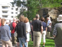 Leppeä kesäsää houkutteli Kasinonsaaren kalliokierrokselle nelisenkymmentä kivistä ja kallioista kiinnostunutta. Kierroksen oppaana toimi geologi Markku Rask, joka on tehnyt elämäntyönsä Geologian tutkimuskeskuksessa (GTK) Espoossa ja Rovaniemellä. Osallistujat saivat tietää, että Kasinonsaarten kallioperä on kauttaaltaan gneissiä, jonka tunnusomainen piirre on liuskeisuus kuten taustalla näkyvässä kalliossa. Suomen kallioperän yleisin kivilaji on graniitti, gneissi on toiseksi yleisin.